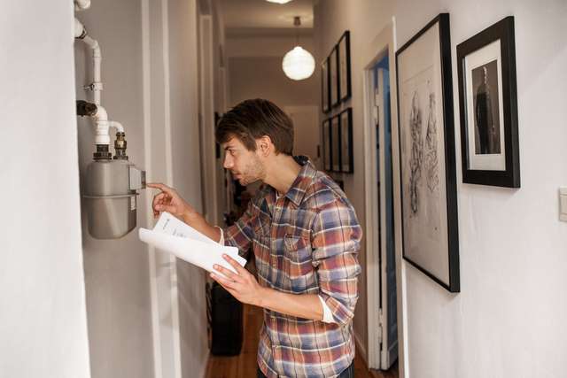 Homme qui lit son compteur d'énergie