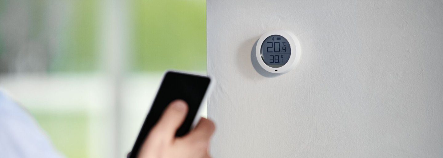 Mains et smartphone devant domotique