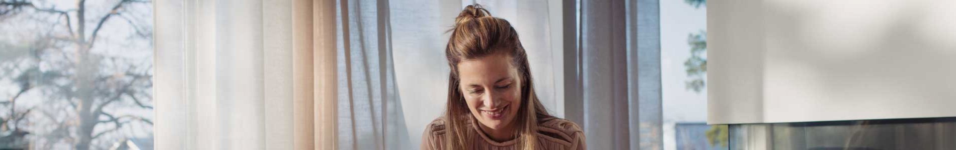 Femme qui sourit devant son ordinateur