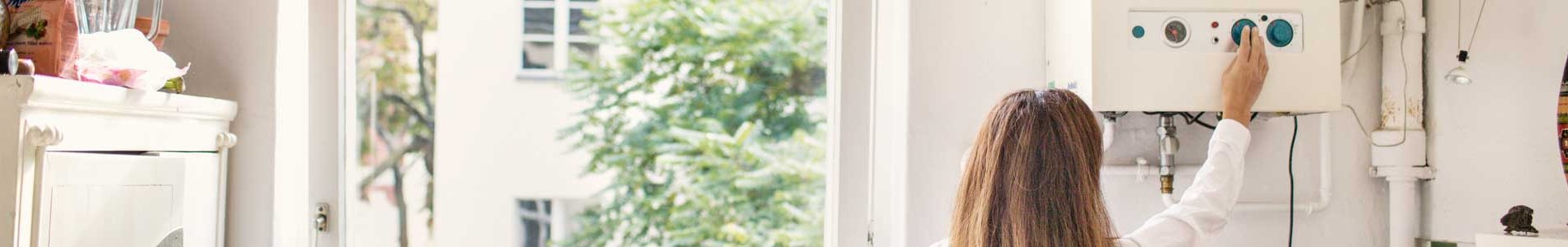 Femme qui contrôle son chauffe-eau