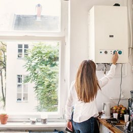 Femme qui contrôle son chauffe-eau