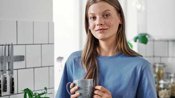 femme tenant un mug dans sa cuisine